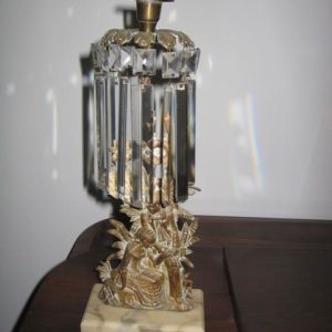 A table lamp with a glass shade and a metal statue.